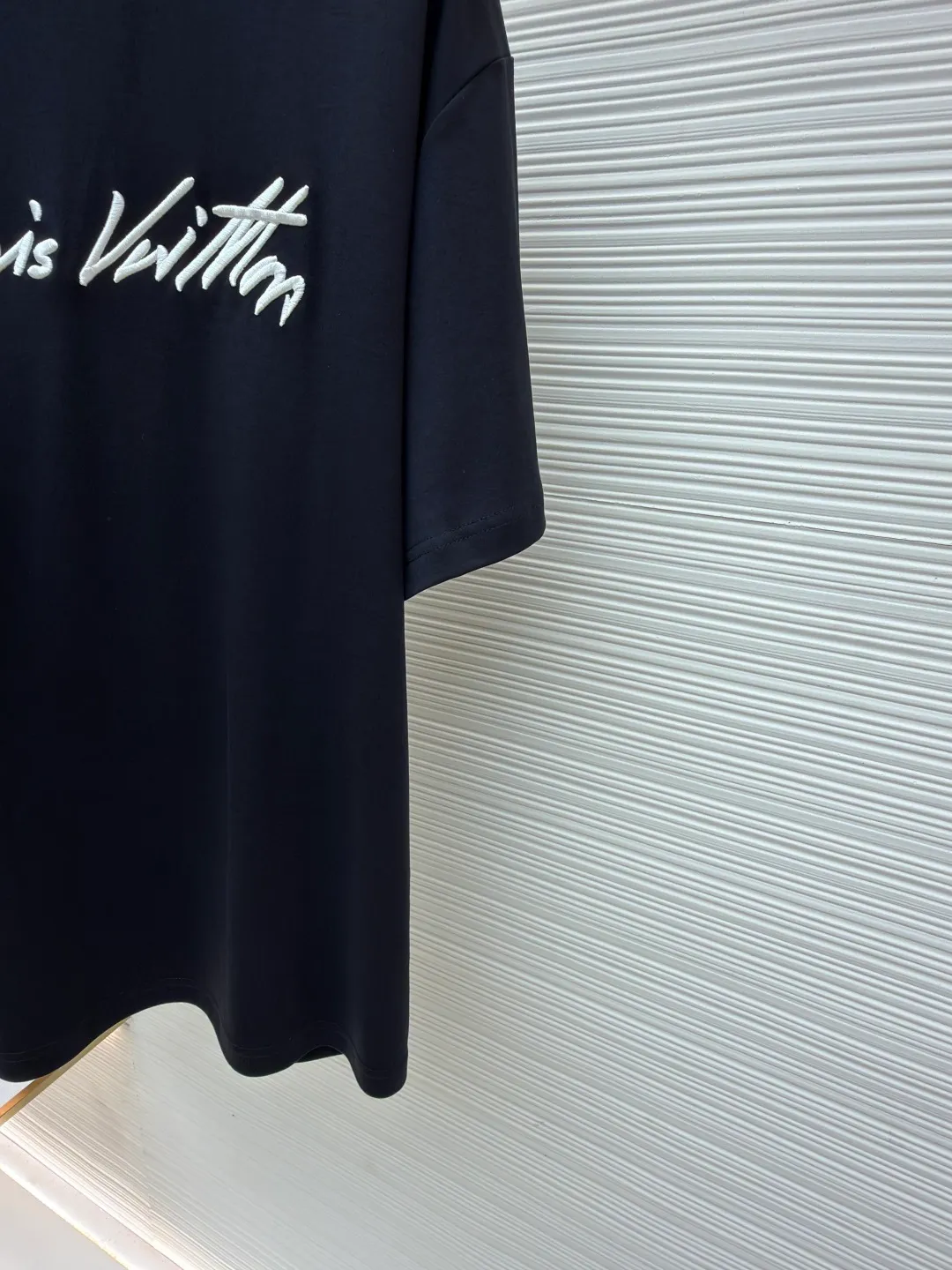 LOUIS VUITTON round neck short sleeves with hand lettering embroidery ●Item number: 1681408-X95 ●Material: long-staple cotton fabric ●Technology: embroidery production ●Color: black ●Version: fitted version ●Weight: about 230 grams ●Size: S-M-L-XL ●Description: Restore 60S single yarn double-sided long-staple cotton, weight 170g; with 32S 1×1 thread, 300g. After being treated with liquid ammonia, it looks like a water-gloss machine. The cloth surface is smooth and has a clear texture, with a slight luster and strong texture. The cotton fiber length of the fabric is long. The advantage of this feature is that after being spun into yarn, the surface of the yarn is smoother, less rough and has a delicate feel. The thin and long features give it a flexible texture, soft skin feel and fabric luster. The front side shows the thickness changes of 3D handwritten font embroidery handwriting strokes and the design pattern after the continuous strokes are simplified; the three-dimensional effect is achieved through multi-layer embroidery threads, filling materials and special stitching methods. Jagged edges are prone to appear on curves and corners; add foam embroidery to the bottom layer of the embroidery and then cut off the excess to form a three-dimensional bulge and improve the smoothness of the lines. Standard H hanging fit with shoulder-length design. The vertical version emphasizes that the width of the shoulders, waist, and hem are basically the same, and it is simple and loose. The short sleeves are tailored to fit the body of the wearer. At the same time, the neckline, cuffs and hem of the short sleeves are all designed with double lines. The overall wiring is straight and delicate, the fabric is comfortable and soft, and the color is consistent without color difference. It can be matched with the same style to create a fashionable look and control various occasions. Customized accessories, complete with three standards, same style for men and women!